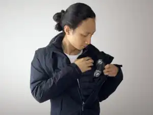 An actor shows two bullet hit squibs attached with duct tape to the inside of the jacket.