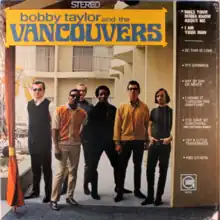 The band standing together, posing for the camera