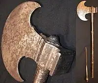 Sindhi tabar battle axe, late 18th century or earlier, crescent shape 12&nbsp;cm (5&nbsp;in) long head with a square hammer opposite of the blade, 55&nbsp;cm (22&nbsp;in) long steel haft, the end of the haft unscrews to reveal a 12&nbsp;cm (5&nbsp;in) slim blade. Heavily patinated head and handle with traces of engraving.