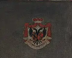 Red, white and blue coat of arms against a dark flat background