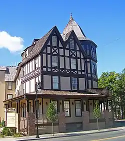 A brown and cream colored building with peaked and pointy roofs