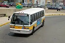 A transit bus in a station busway in an urban area