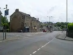 Road junction with view towards three-storey sandstone buildings