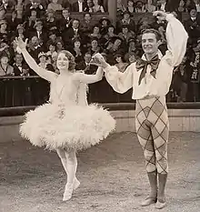 Man an woman taking bows before a crowd