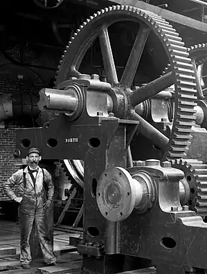 The Poole & Hunt ironworks in Baltimore, Maryland, produced gears in a remarkable variety of sizes and types. This rare photo also shows one of the workmen at the ironworks. Photographer and workman are unknown. Date 	c. 1900