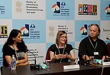 Colour photograph of Nisha Pahuja (left) at a press conference with Nicole Newnham (centre) and Walter Steffen (right)
