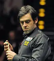 Ronnie O'Sullivan chalking his cue stick.
