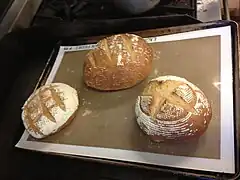 Loaves of rye bread showing several different kinds of scoring patterns