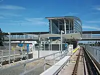 Approaching Sea Island Centre station from the west. Access to the station is via an elevated walkway above the tracks and adjacent roads.