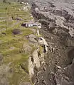 A house on the edge of a newly formed cliff.