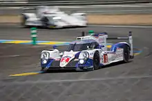 White-and-blue race car rounding a curve
