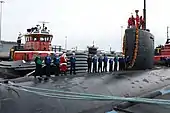 Santa Claus stands with sailors aboard Miami during the submarine's return to Naval Submarine Base New London after an eight-month deployment. (2 December 2009)